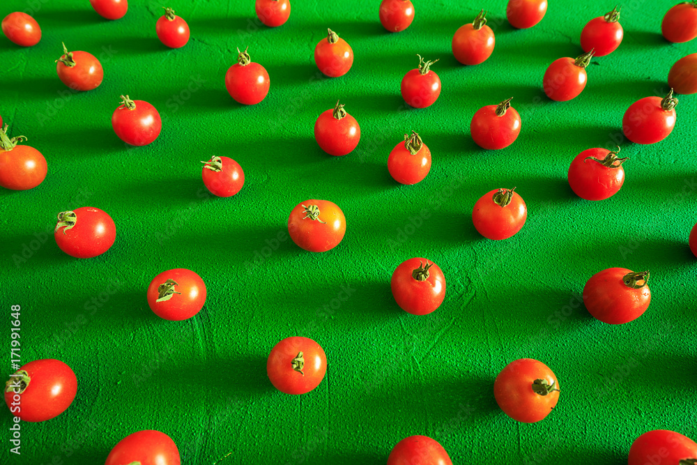 Red tomatoes cherry, scattered in a chaotic manner on a green background. Food background. Red tomatoes cherry, scattered in a chaotic manner on a green background. Food background.