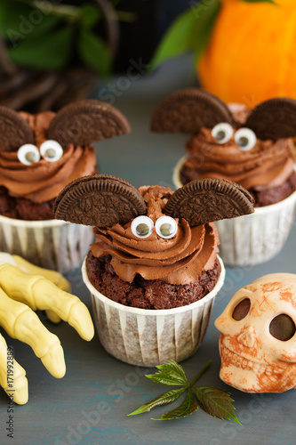 Chocolate muffins, with a chocolate cream in the form of bat on Halloween.