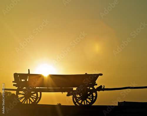Old cart at sunset in contour light on a dark yellow background