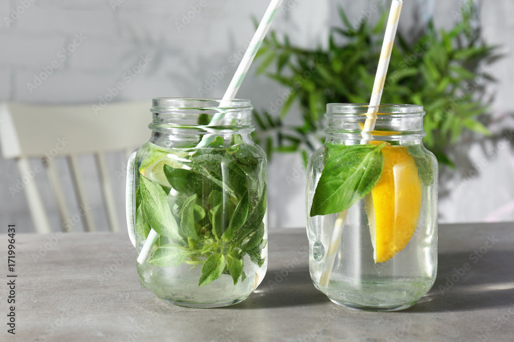 Jars with basil water on table Jars with basil water on table