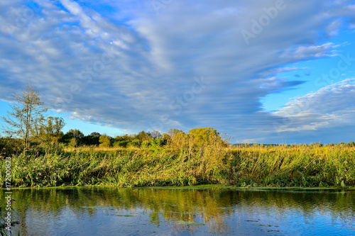 Colorful autumn landscape with a river and clouds