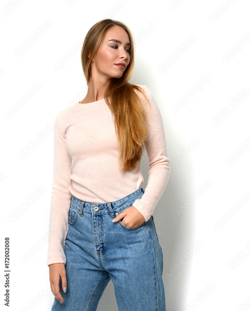 Young happy beautiful woman posing in new fashion blue jeans and pullover Young happy beautiful woman posing in new fashion blue jeans and pullover