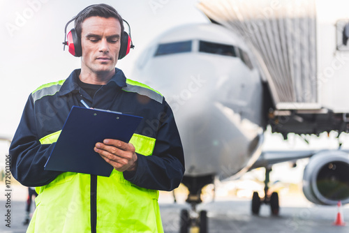 Serious male worker noting data