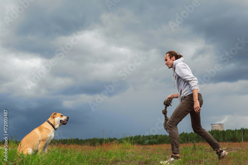 A man playing with a dog photo