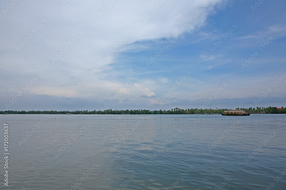 Fototapeta premium Houseboat on serene and still water on a sunny day on the Kerala backwaters, India
