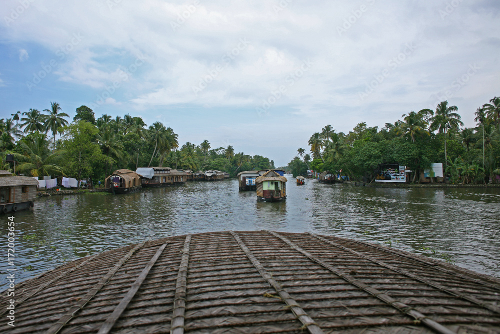Passing houseboats on a sunny day on the Kerala backwaters, India