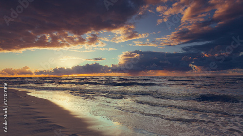 Beatiful sunset with clouds over sea and beach