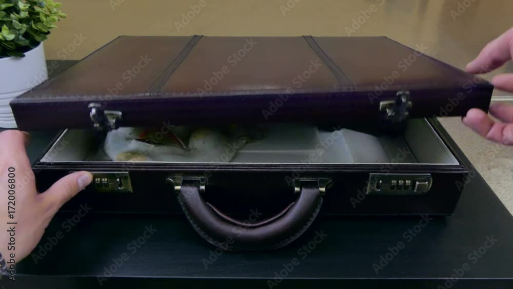 Opens the case with a mask and a gun Opens the case with a mask and a gun