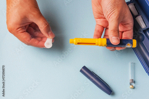 A man holds a syringe for subcutaneous injection of hormonal drugs in the IVF protocol (in vitro fertilization). Medical product in ampoules. Preparation for pregnancy. Helping Wife