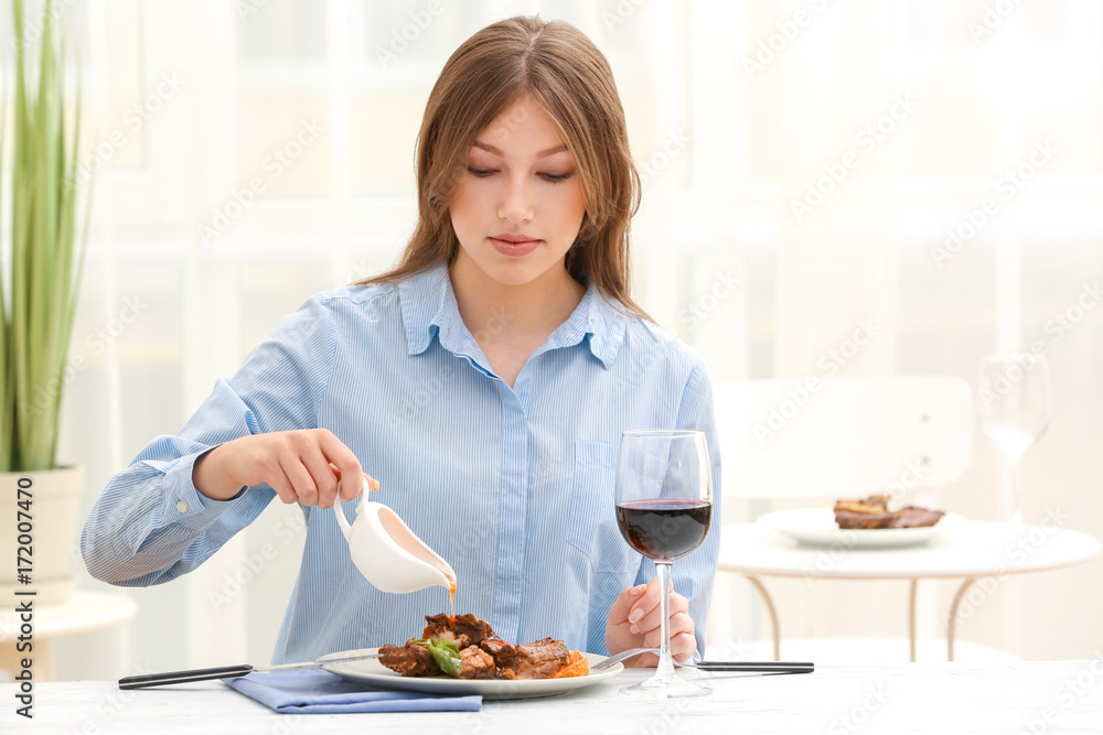 Young woman eating delicious ribs in restaurant Young woman eating delicious ribs in restaurant