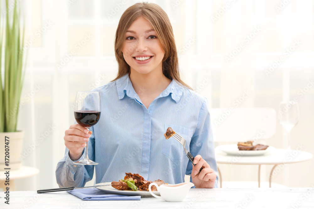 Young woman eating delicious ribs in restaurant Young woman eating delicious ribs in restaurant