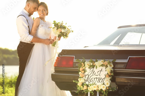 Happy wedding couple near d...