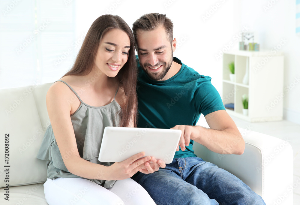 Young couple searching information using tablet at home Young couple searching information using tablet at home