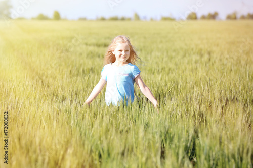 Happy little girl in green field