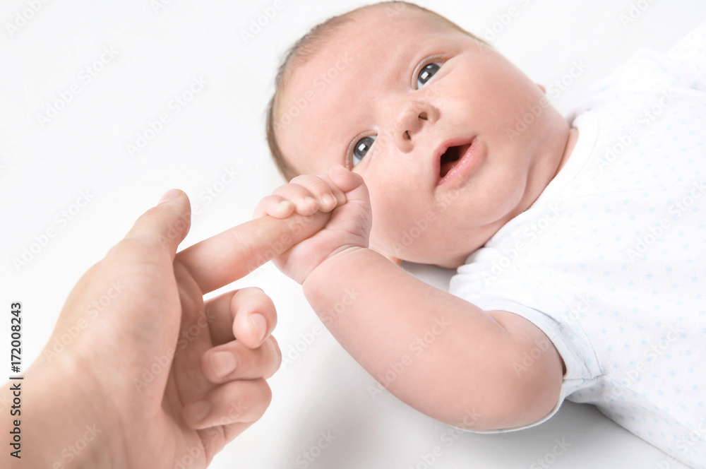 Cute little baby holding mother's finger on white background Cute little baby holding mother's finger on white background