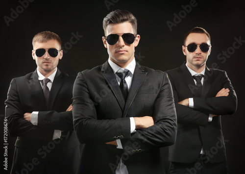 Handsome bodyguards on dark background