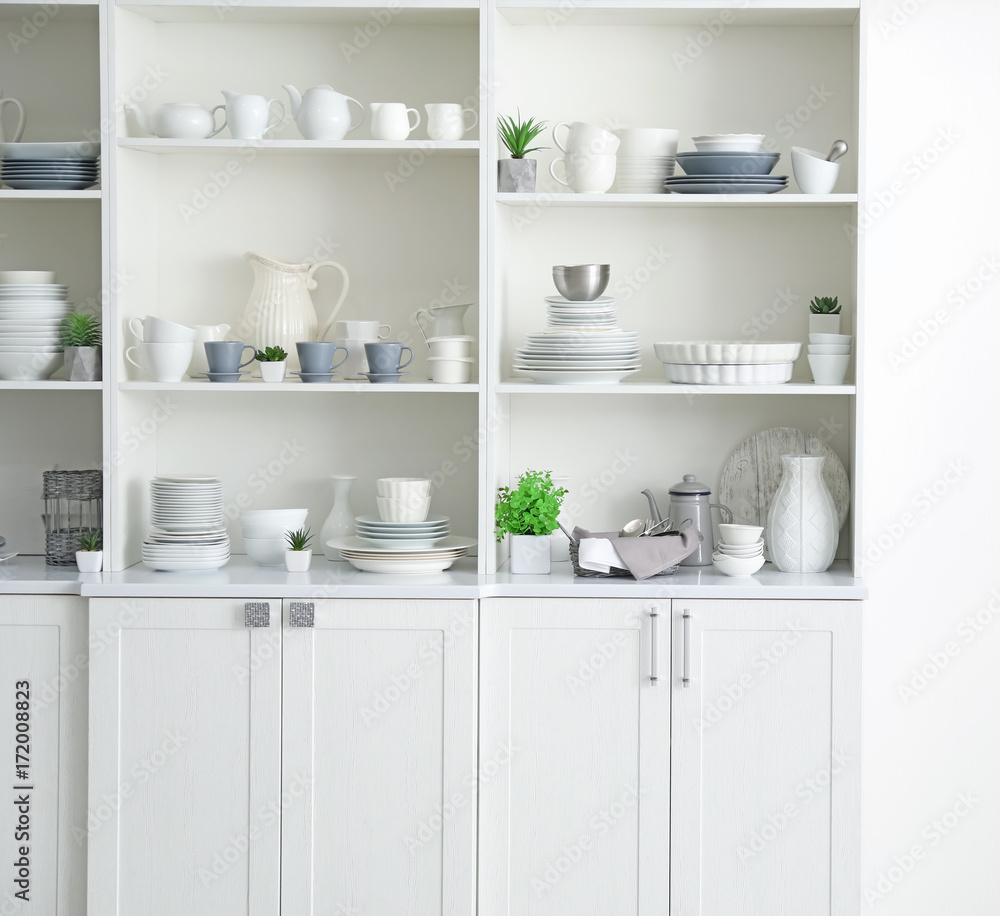 White storage stand with ceramic dishware in kitchen White storage stand with ceramic dishware in kitchen