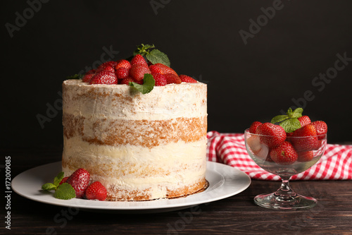 Delicious strawberry cake on wooden table