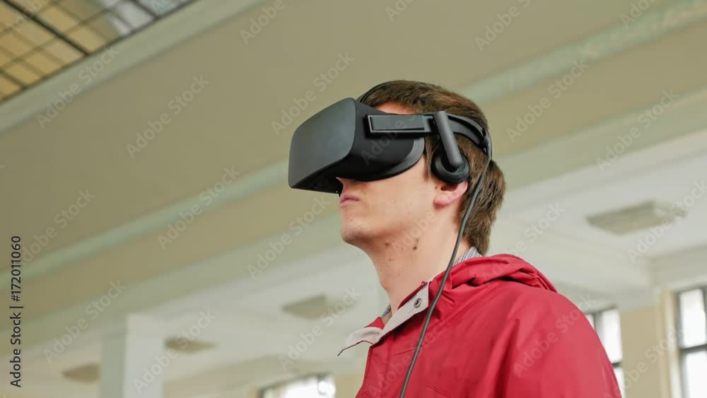 Teenager in VR headset enjoying virtual reality digital game. Virtual and augmented reality are increasingly used in human lives. Teenager in VR headset enjoying virtual reality digital game. Virtual and augmented reality are increasingly used in human lives.