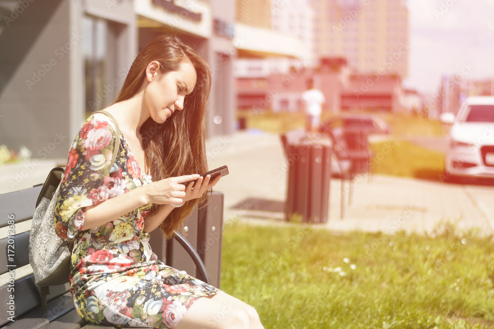 Woman on a city bench with a smartphone Woman on a city bench with a smartphone