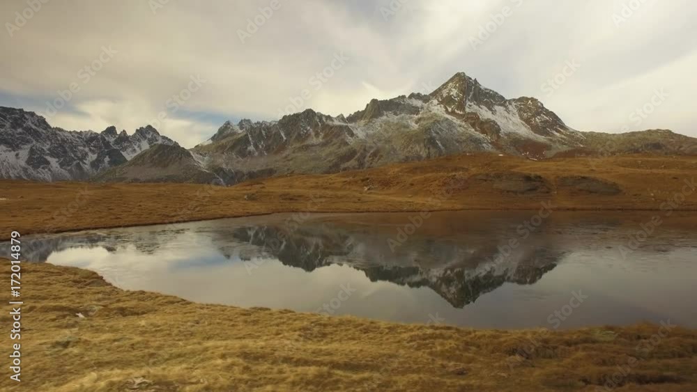 side POV walking on fall valley lake and snowy mounts approaching sunset.Sunny autumn day Hiking in colorful red forest wild nature mountain outdoors.Alps Devero.4k point of view establishing video side POV walking on fall valley lake and snowy mounts approaching sunset.Sunny autumn day Hiking in colorful red forest wild nature mountain outdoors.Alps Devero.4k point of view establishing video