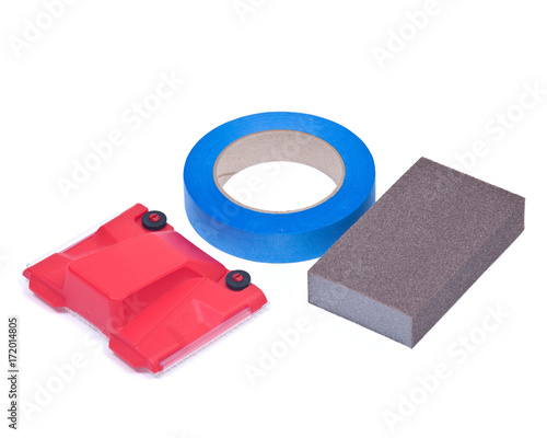 Blue painter's tape, jumbo sanding sponge and paint trimline edger isolated on white background photo