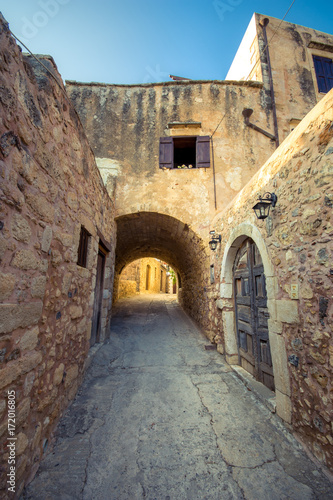 Old narrow street with stone arch at Atsipopoulo, Rethimno, Crete, Greece.