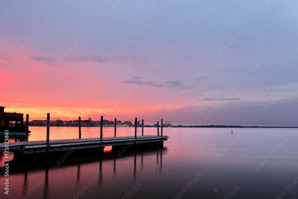 Fishing pier and skyline of Madison of Wisconsin at sunset viewing from Olin Turville Park. Photo showing the state capital and lake Monona with reflections, Madison, Wisconsin, USA. 