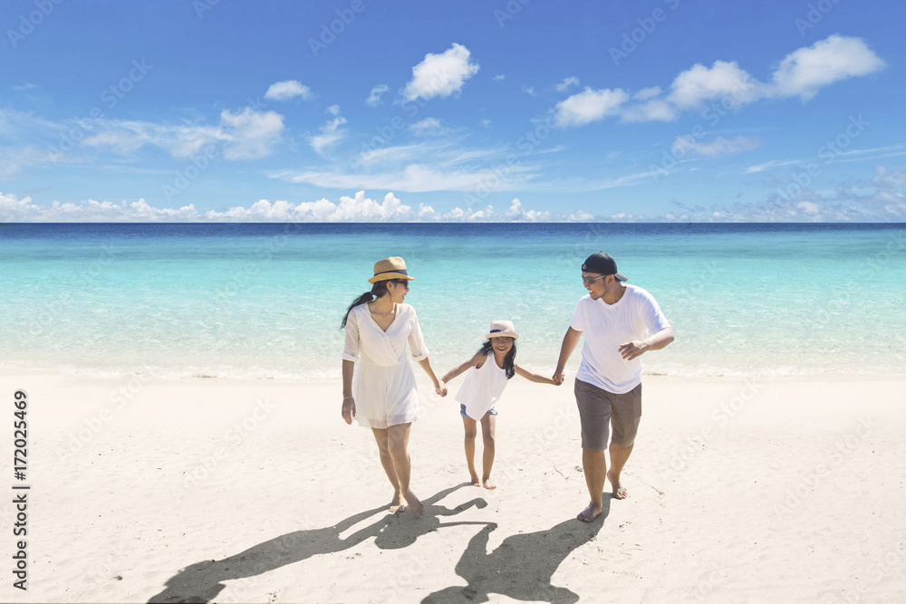 Young parents with daughter on the beach