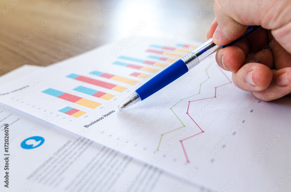 Man showing business graph on wood table Man showing business graph on wood table