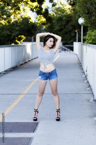 Asian American Woman Standing Outdoors In Jeans Shorts