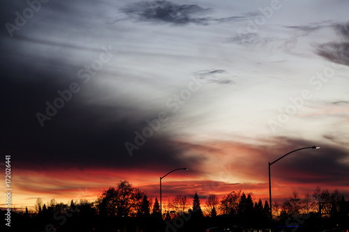 Cloudy Sky Sunset With Street Lamps And Trees