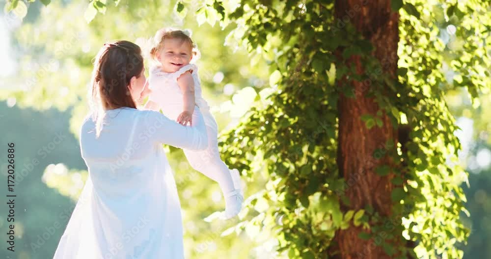Young Mother with Baby Girl Enjoying Sunny evening in the Park. Slow Motion 120 fps, 4K. Mom playing with Toddler Daughter Outdoors. Happy childhood and Parenthood. Cinematic Family Young Mother with Baby Girl Enjoying Sunny evening in the Park. Slow Motion 120 fps, 4K. Mom playing with Toddler Daughter Outdoors. Happy childhood and Parenthood. Cinematic Family