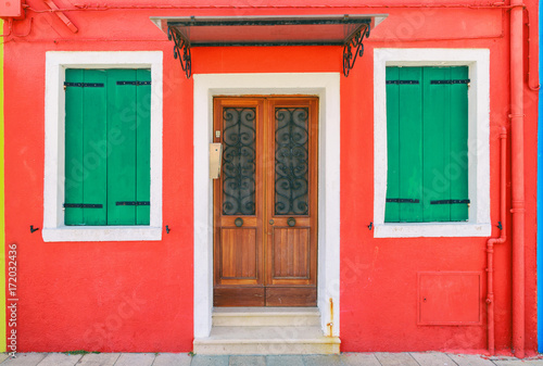 Picturesque windows with shutters of red house on the famous island Burano, Venice, Italy