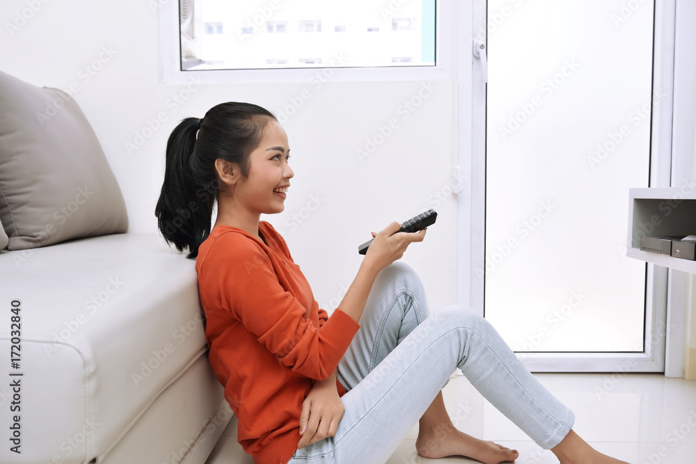 Young asian woman watching television while sitting Young asian woman watching television while sitting