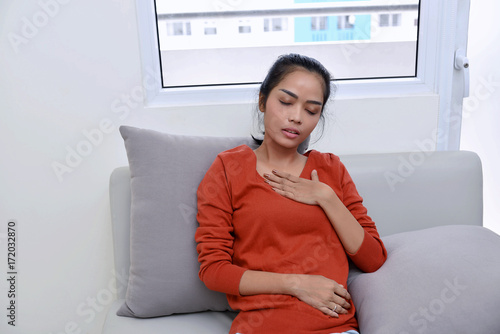 Obraz na plátne Young asian woman feeling pain in her chest