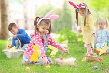 Children having fun in park. Easter egg hunt concept