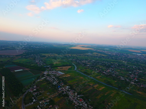 Aerial view of beautiful village, houses, roads. Sky, clouds.