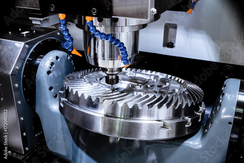 A modern CNC milling machine makes a large cogwheel. photo