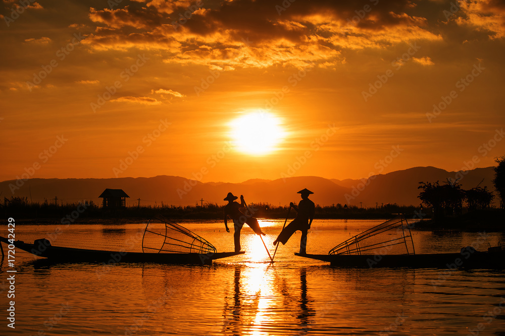 Inle fishermen are known for practising a distinctive rowing style which involves standing at the stern on one leg and wrapping the other leg around the boat paddle, Myanmar