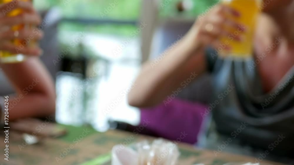 Four friends toast their beer glasses and drink. Clinking glasses in outdoor pub Four friends toast their beer glasses and drink. Clinking glasses in outdoor pub