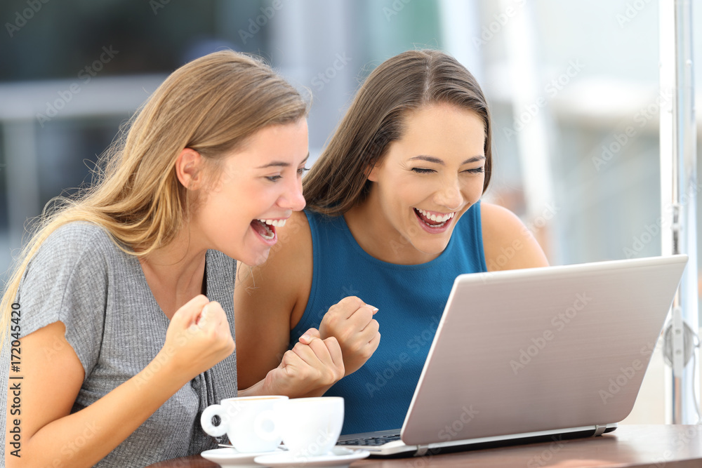 Excited friends finding on line content in a laptop Excited friends finding on line content in a laptop