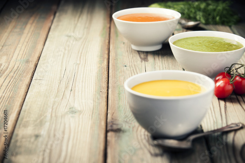 Variety of cream soups over old wood background