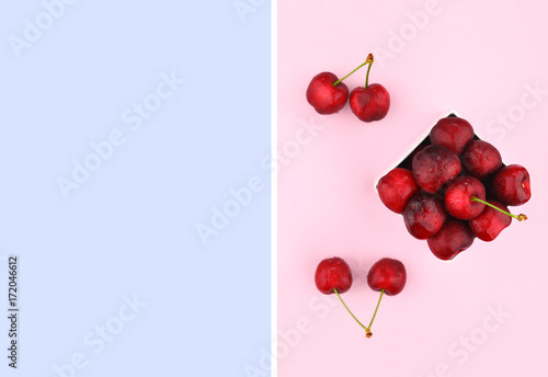 Ripe sweet cherries on pink background.
