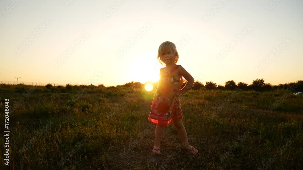 The girl is spinning in the field in the rays of the sunset. The girl is spinning in the field in the rays of the sunset.