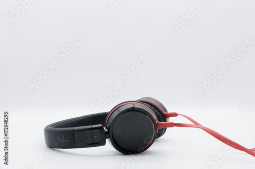 Large black with red headphones standing with a hanging wire on a white background