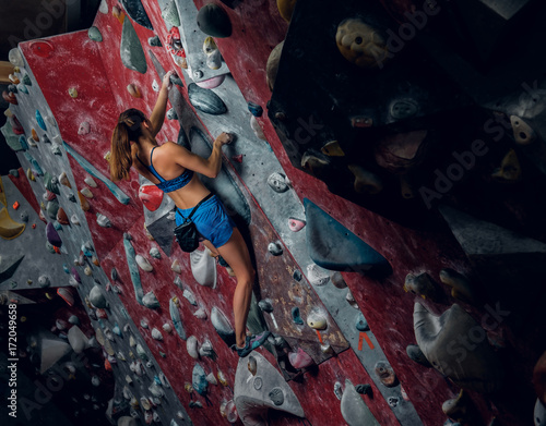 Female climber. Extreme indoor climbing.