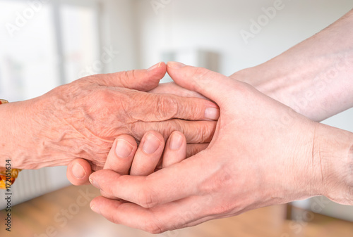 Man holds hands of eldery woman. Senior help concept. photo