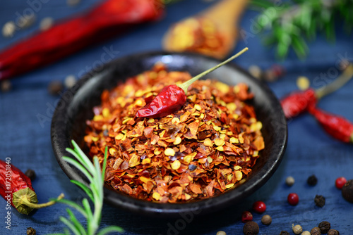 Foto Scharfes Chili Gewürz in Schüssel und Chilischote