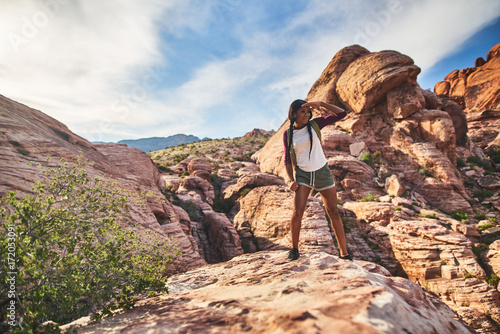 athletic african american woman standing on cliff edge at red rock canyon park